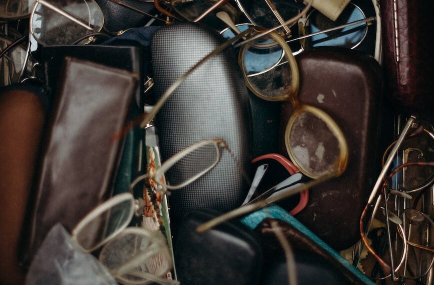 black and brown leather bifold wallet beside black framed eyeglasses