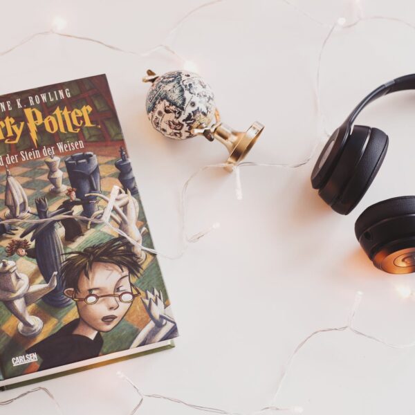 harry potter book and black headphones with trinket