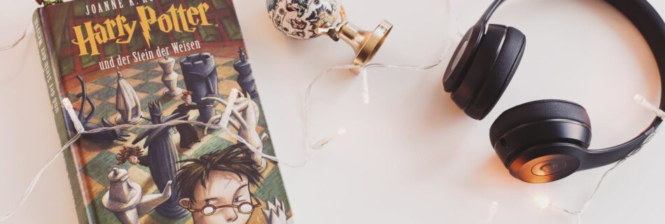 harry potter book and black headphones with trinket