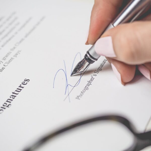 person holding silver pen signing photographers signature