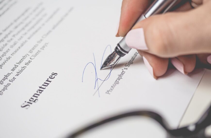 person holding silver pen signing photographers signature