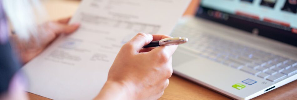 person holding pen and paper