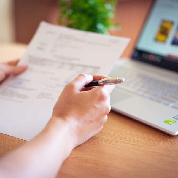 person holding pen and paper