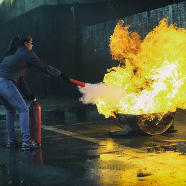 woman using fire extinguisher to eliminate fire