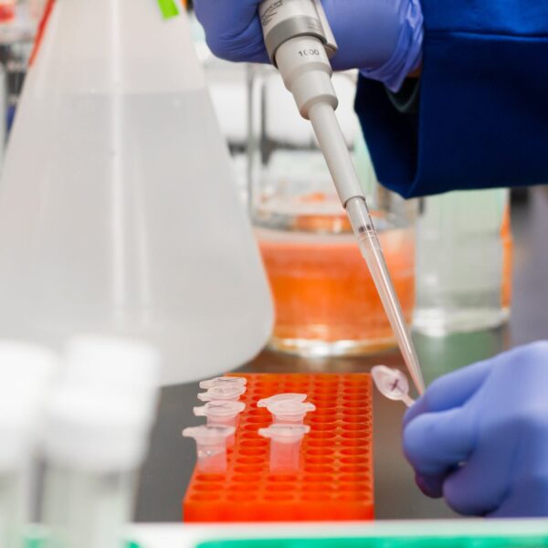 person putting a drop on test tube